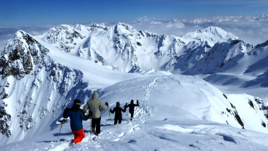 4 personnes courent et pratiquent le trail dans la neige sur les sommets de Belledonne.