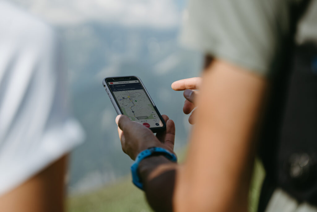Deux traileurs étudient leurs parcours sur la carte interactive on piste sur leur smartphone