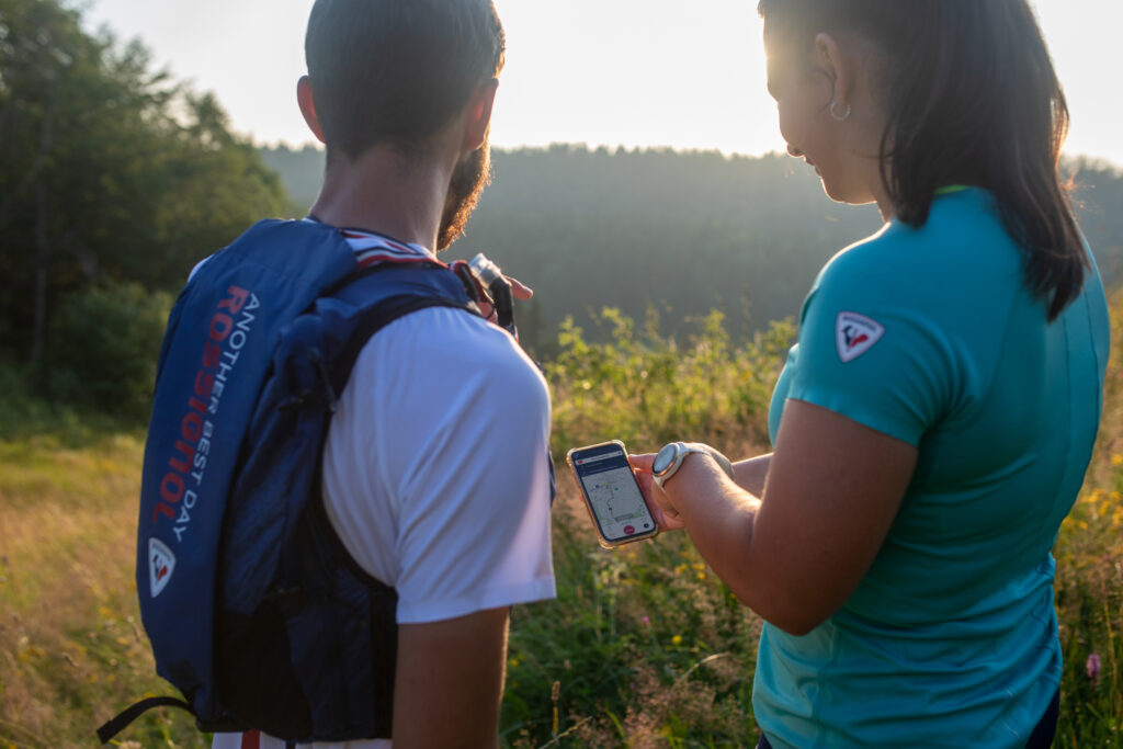 Deux traileurs étudient leurs parcours sur la carte interactive de on piste sur leur smartphone