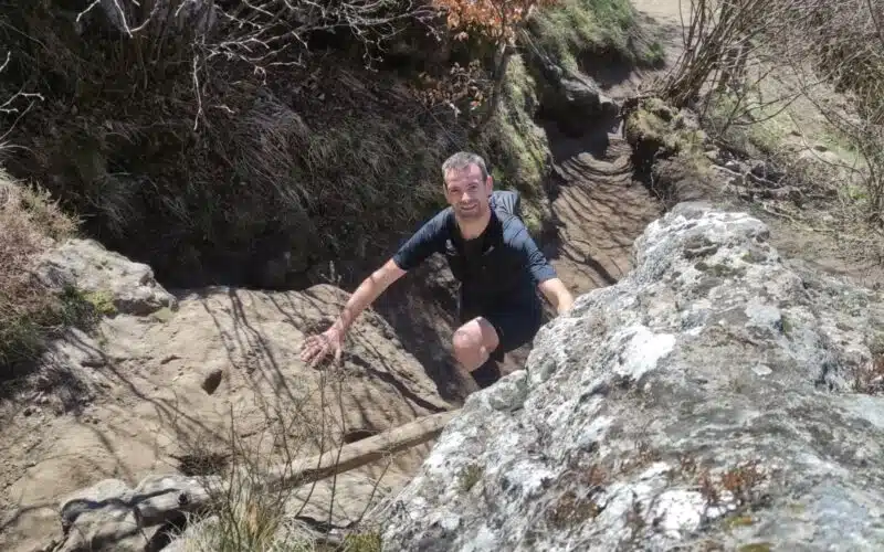 Participant courant sur un sentier de trail dans les Volcans d'Auvergne.